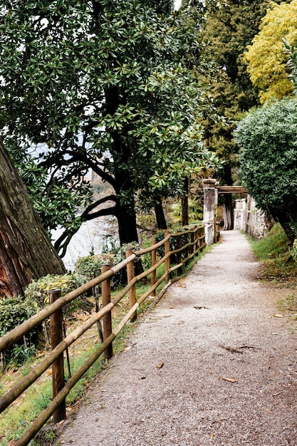 Wooden fence along the path in the green garden villa monastero italy