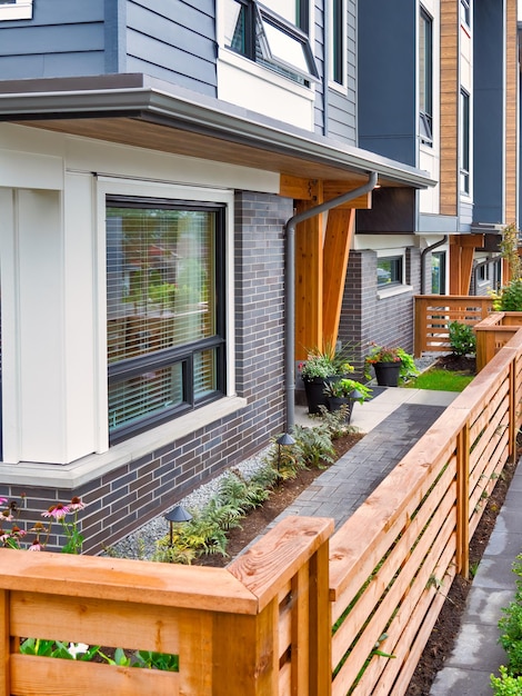 Wooden fence in front of new residential townhouse on foggy day