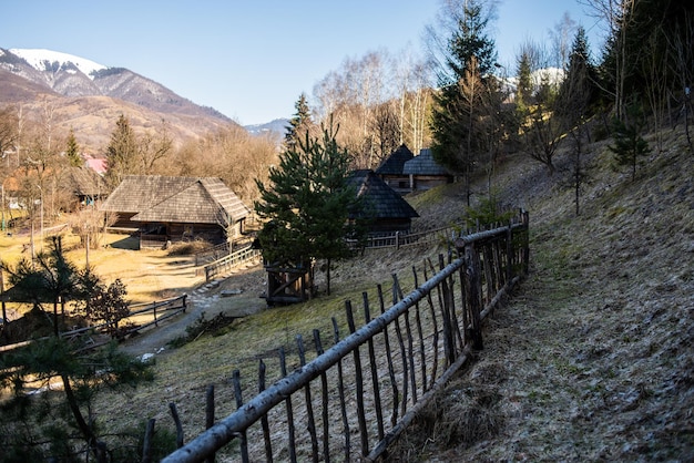 A wooden fence surrounds a house in the mountains