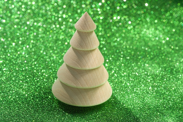 Wooden figure of a Christmas tree on a green shiny background