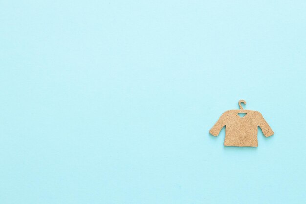 A wooden figure of a clothes hanger on a blue background Shopping concept