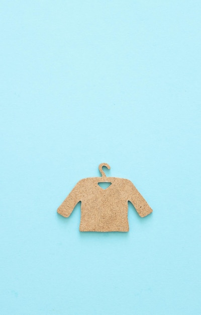 A wooden figure of a clothes hanger on a blue background Shopping concept