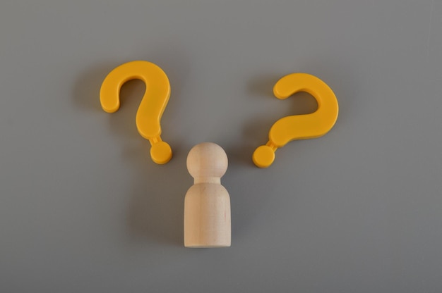 Wooden figure and question mark symbols