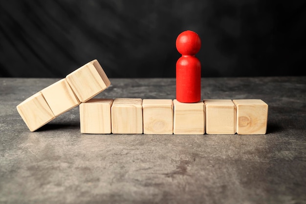 A wooden figure and a row of wooden cubes