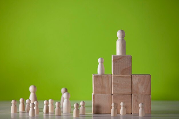 Wooden figures in the form of people below and above a pedestal