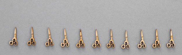 Photo wooden figures in the form of scissors on a grey background