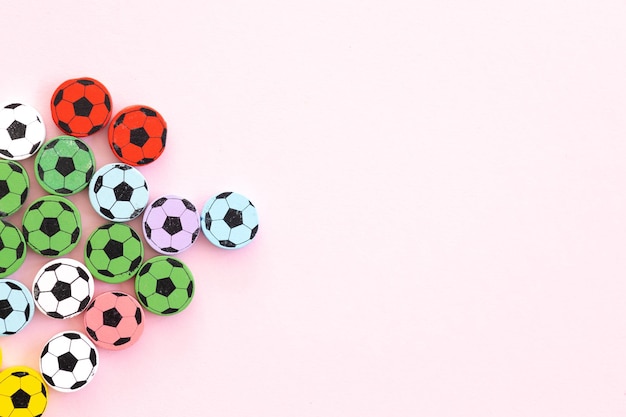 Photo wooden figures in the form of soccer balls on a pink background football time