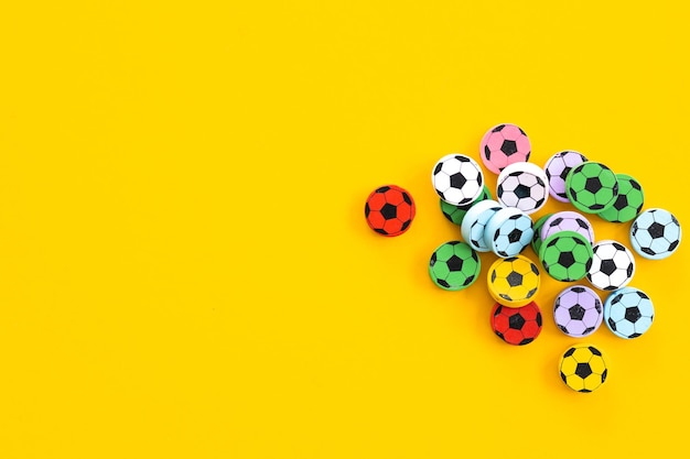 Wooden figures in the form of soccer balls on a yellow background