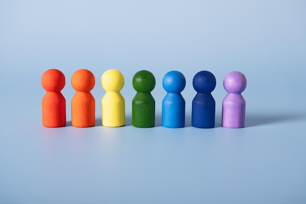 Wooden figures of people painted in the colors of the rainbow Group assembly diversity of species