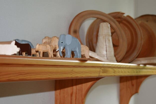 Photo wooden figurines over shelf on wall