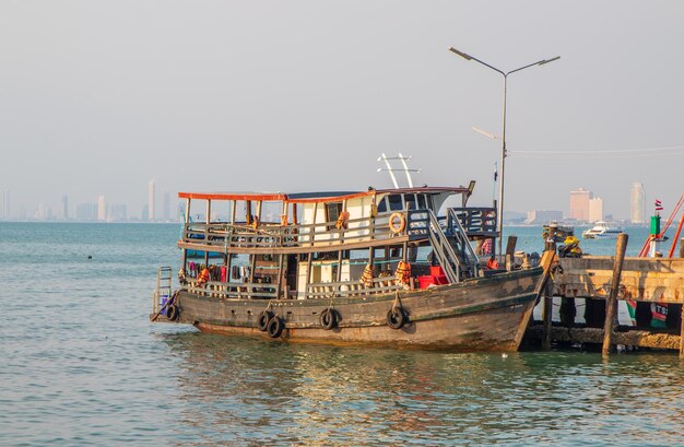 Photo a wooden fishermans boat at the fishing pier in bang saray district chonburi thailand asia