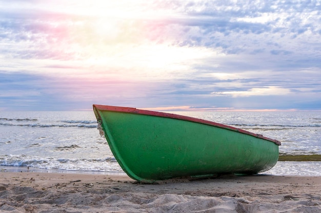 Wooden fishing boat pulled onto the sand of the shore of the sea bay