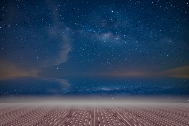 Wooden floor and backdrop of the milky way sky at night
