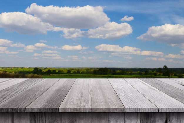 Деревянный пол стола на сельской местности и свежем небе в течение дня фон для дизайна в вашей концепции работы.