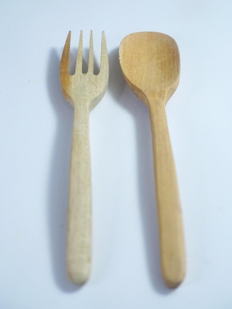 A wooden fork and a fork are next to each other.