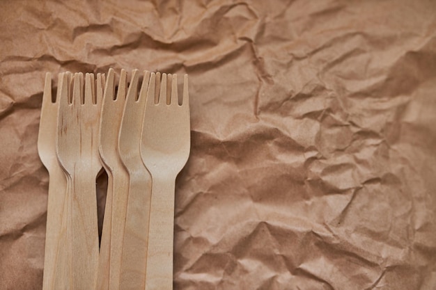 Wooden forks on a background of crumpled paper Eco wooden plugs