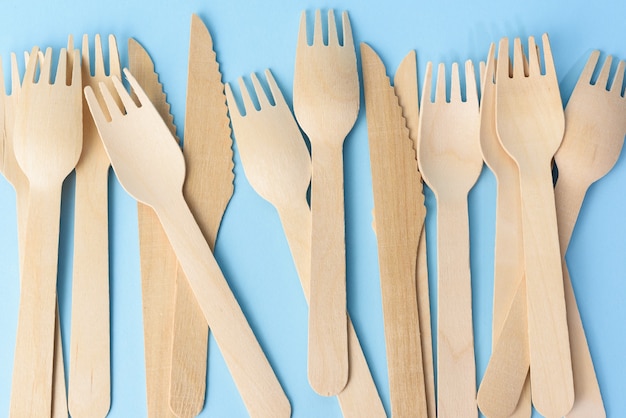 Wooden forks and knives on a blue background, zero waste