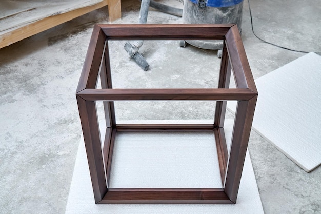 Wooden frame of bedside table made of solid walnut in workshop