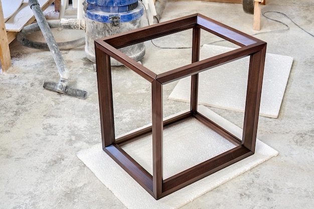 Wooden frame of bedside table made of solid walnut in workshop