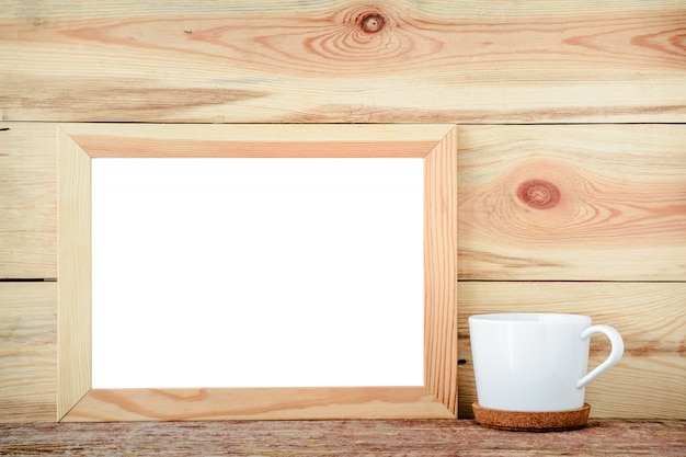 Wooden frame isolated with decorations from a white cup on a wooden background. 