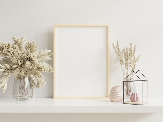 Wooden frame leaning on white shelf in bright interior with plants on the table with plants in pots on empty wall