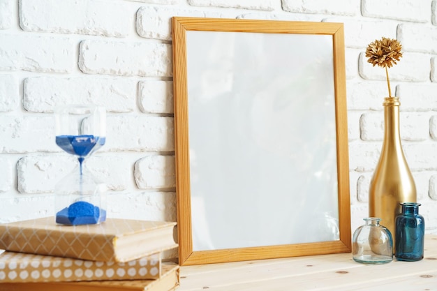 Wooden frame mockup on table with modern vase and books