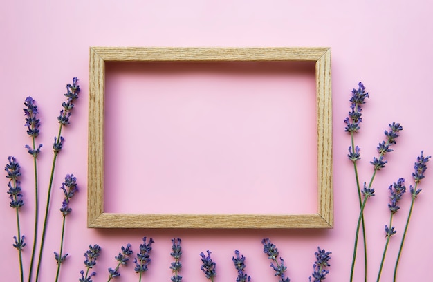 Cornice in legno con bellissimi fiori di lavanda profumata sulla superficie rosa