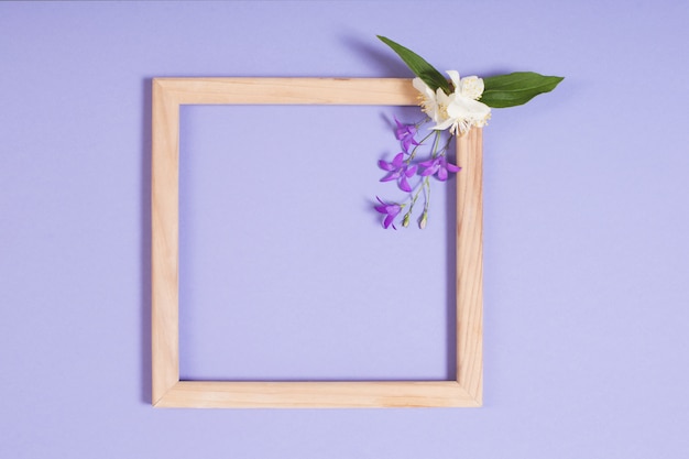 Wooden frame with flowers on purple paper