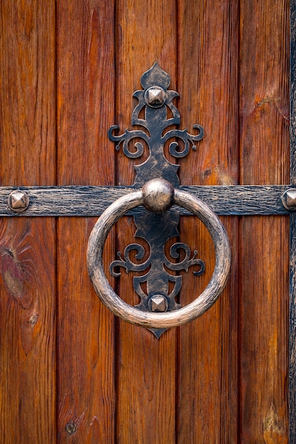 Wooden gate with wrought iron elements close up