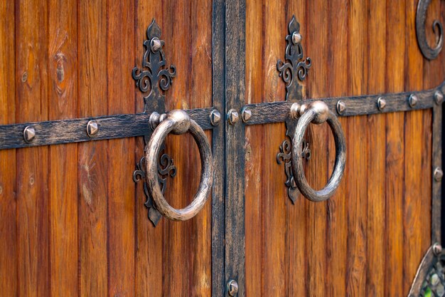 Wooden gate with wrought iron elements close up.