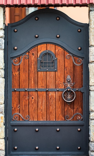 Wooden gate with wrought iron elements close up.