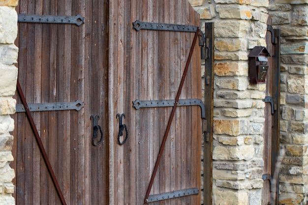 Wooden gate with wrought iron elements close up.