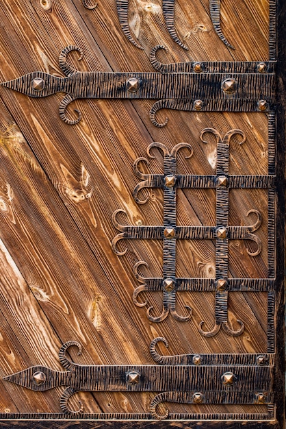 Wooden gate with wrought iron elements close up.