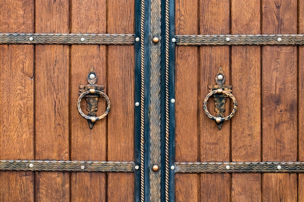 Wooden gate with wrought iron elements close up.