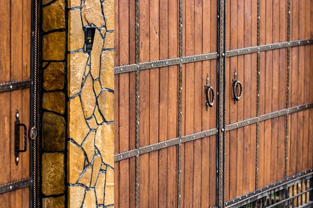 Wooden gate with wrought iron elements close up.