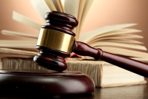 Wooden gavel and books on wooden table,on brown