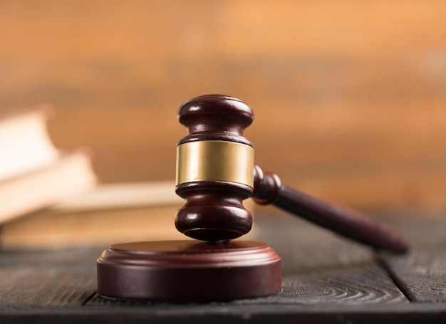 Wooden gavel and books on wooden table