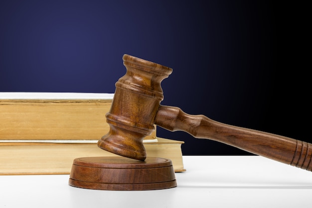 Wooden gavel and books on wooden table