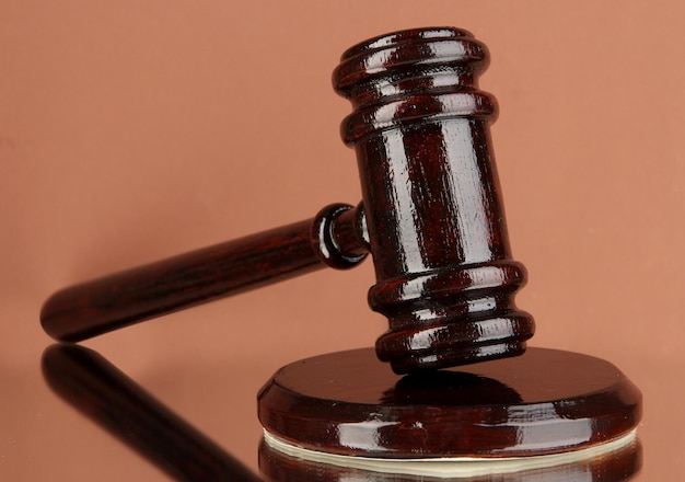 Wooden gavel on brown background