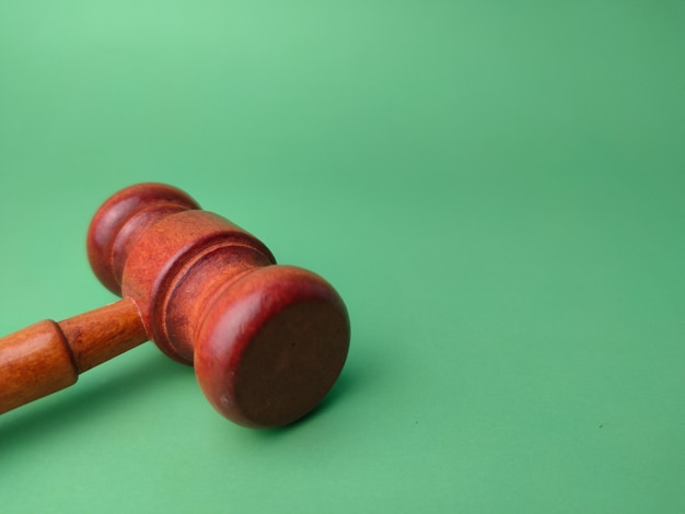 Wooden gavel on a green background with copy space