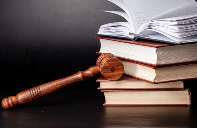 Wooden gavel and juridical books close up