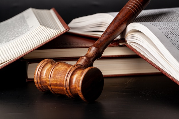 Photo wooden gavel and juridical books close up