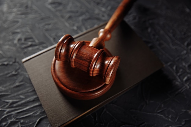 Wooden gavel and legal book on a table.