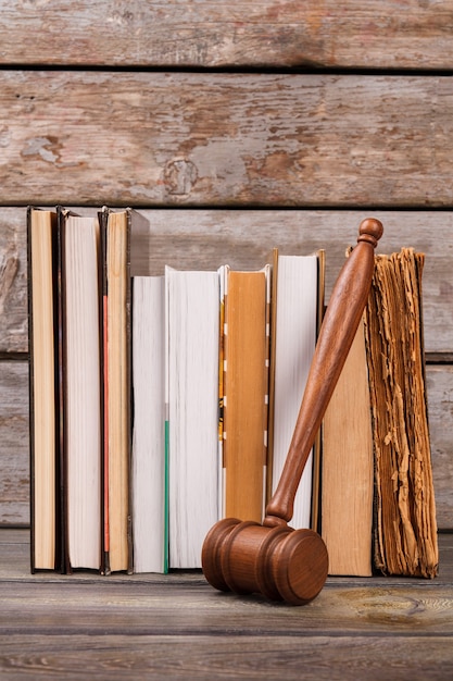 Wooden gavel and old books. Vertical shot wooden judge hammer and aged books vertical shot.