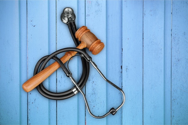 Wooden gavel and stethoscope on wooden background