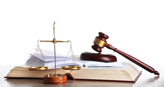 Wooden gavel with justice scales and open books on white background