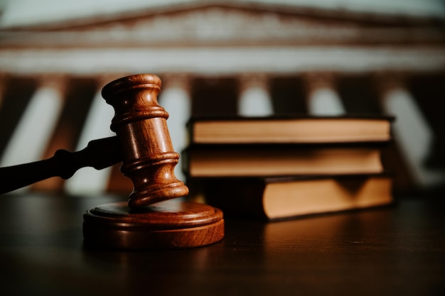 Wooden gavel with law books on background Law and Justice theme