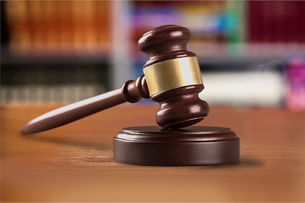 Wooden gavel on wooden table, on  background