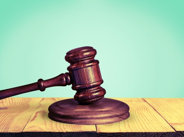 Wooden gavel on wooden table, on  background