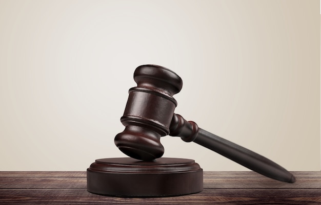 Wooden gavel on wooden table, on  background